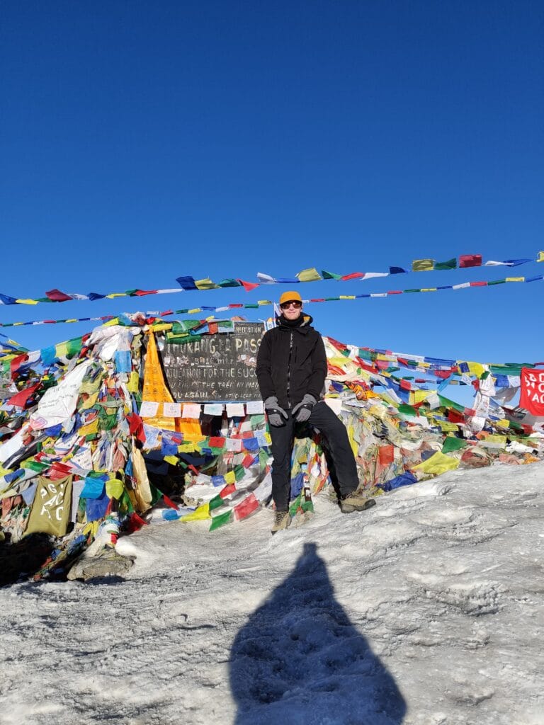 Trekker standing at Thorong La Pass at 5416m on the Annapurna Circuit