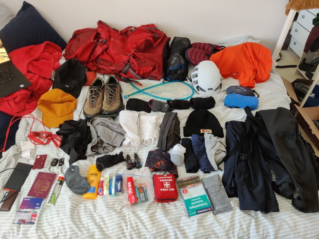 Alta Via 4 Packing List showing all the via ferrata and trekking clothing and equipment laid on a bed