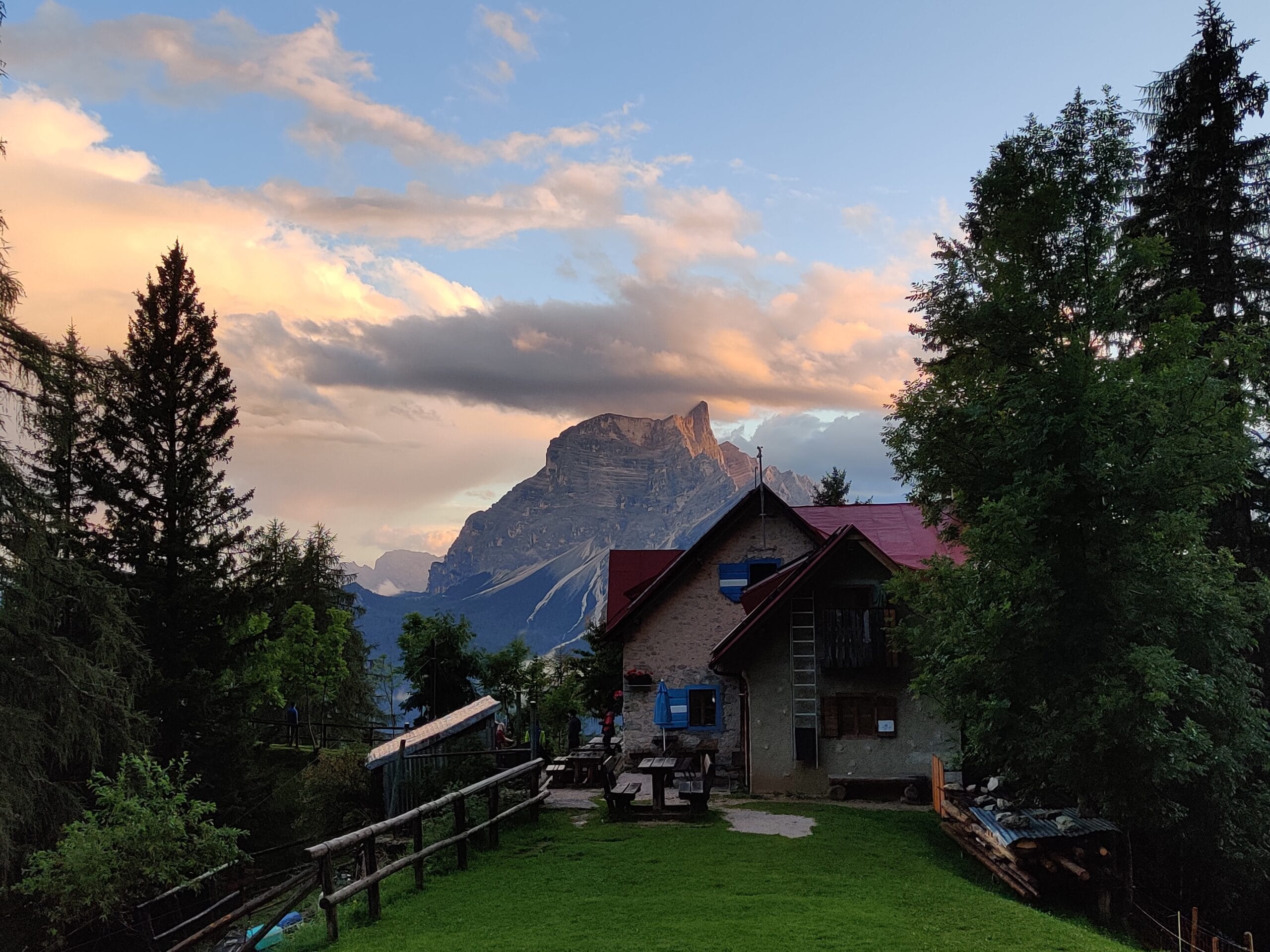 Sunset view from Rifugio San Marco with trees either side of the mountain hut