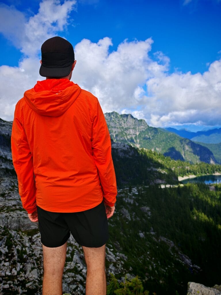 Hiker stood admiring the mountain view wearing an Arc'teryx Proton LT facing away from the camera