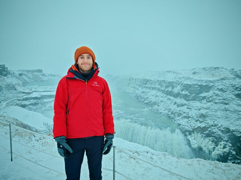 Man stood at gullfoss Falls in Iceland wearing the Arc'teryx Beta AR and Mountain Equipment Guide Glove in winter weather