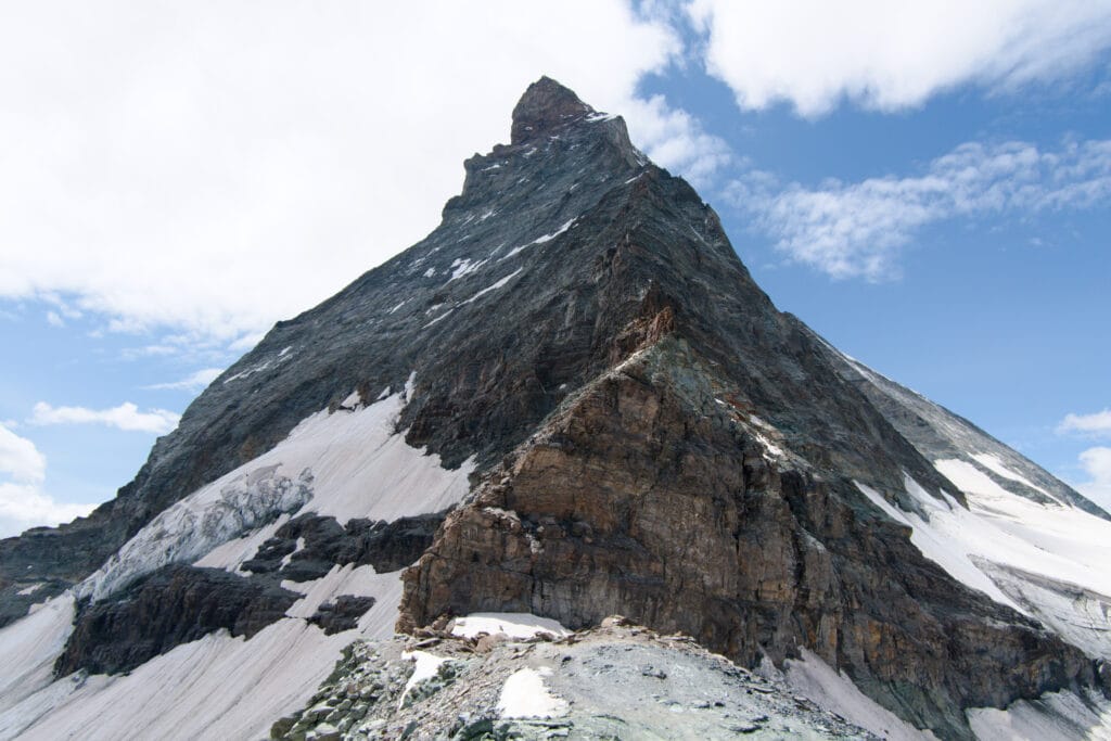 Close-up of the Matterhorn face showing snow patches and climbing route at the base next to Hörnlihütte. 