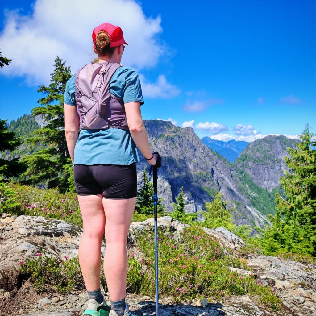 Female hiker looking out across mountains wearing the Salomon Women's Active Skin 4 Hydration Running Vest