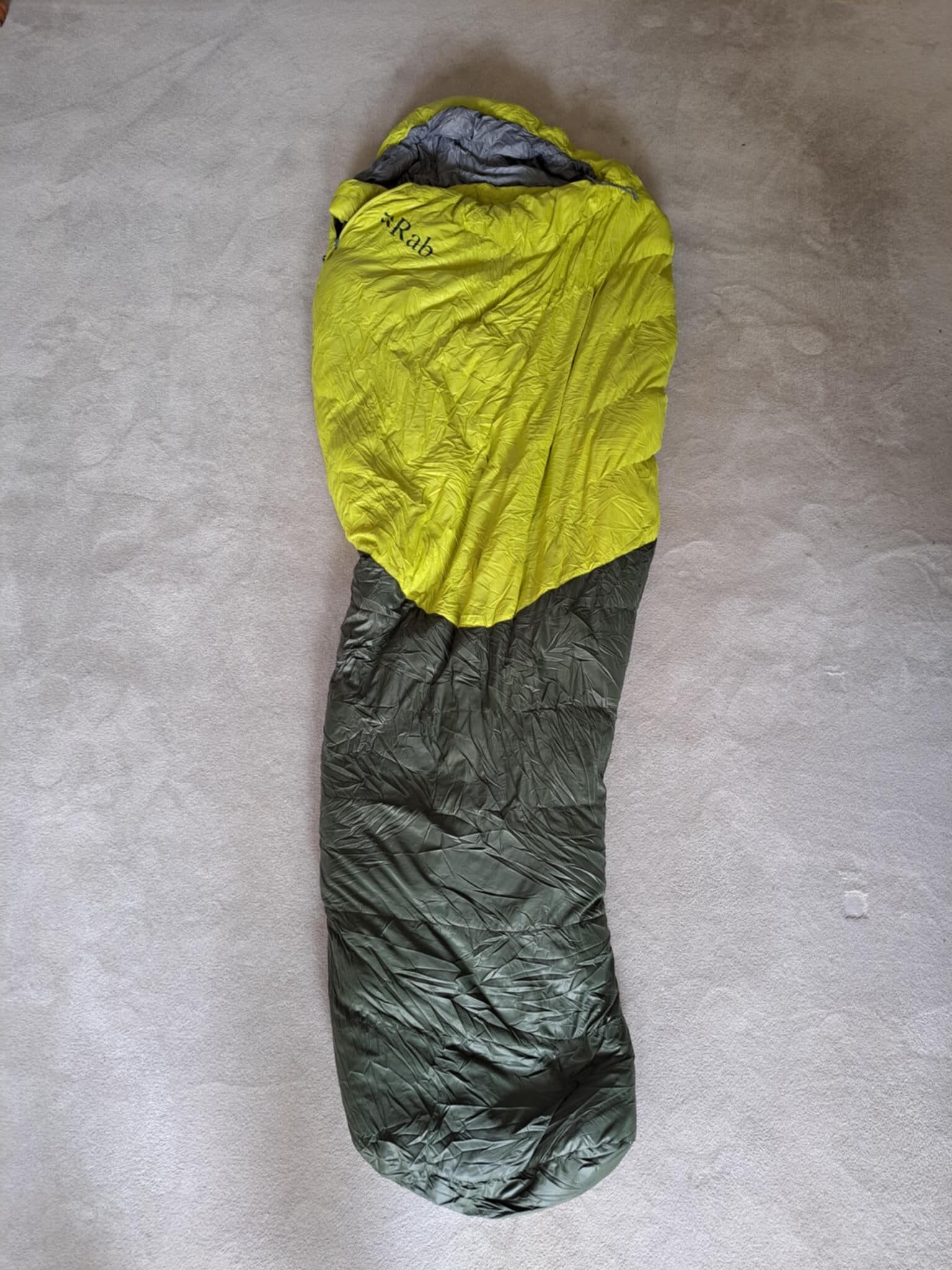 The Rab Alpine 800 sleeping bag unrolled inside a tent on a mountain trek.