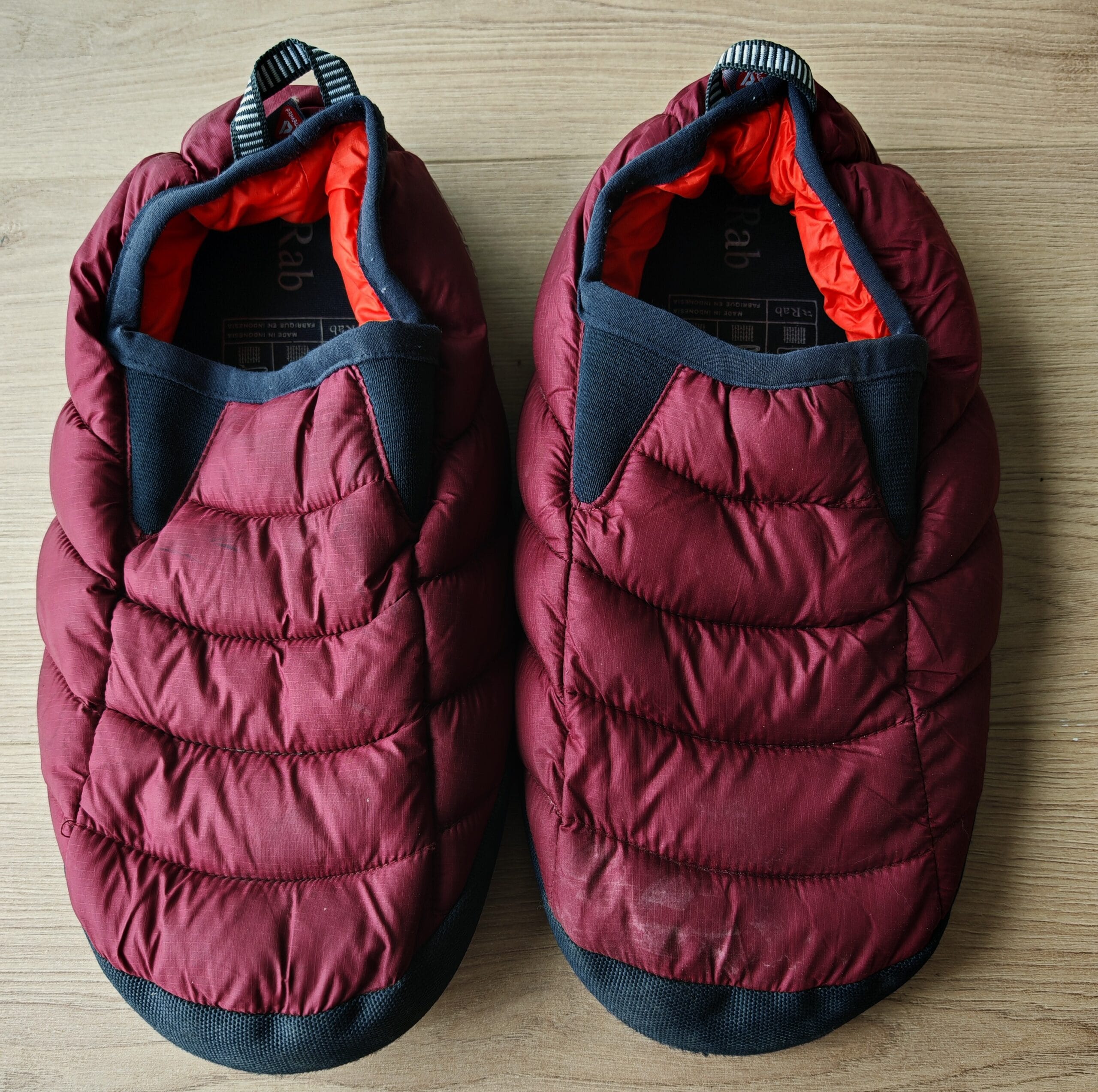 Rab Cirrus Hut Slippers sitting outside a tent, demonstrating their ideal use as basecamp recovery shoes.
