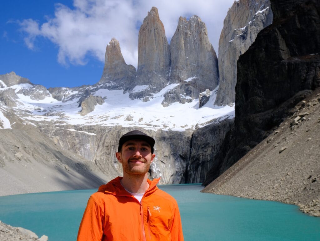 Trekker in front of Mirador Base Torres in Patagonia wearing the Arc'teryx Proton LT