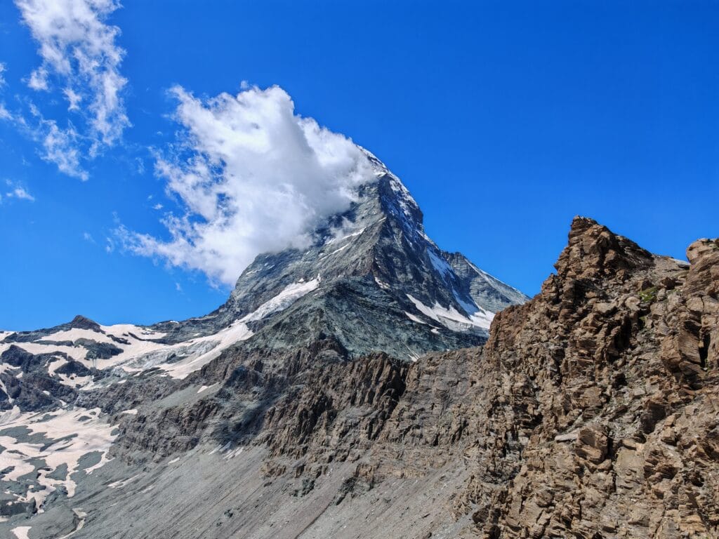 Close-up of the Matterhorn summit showing the rocky Hörnli ridge and snow patches towards Hörnlihütte.