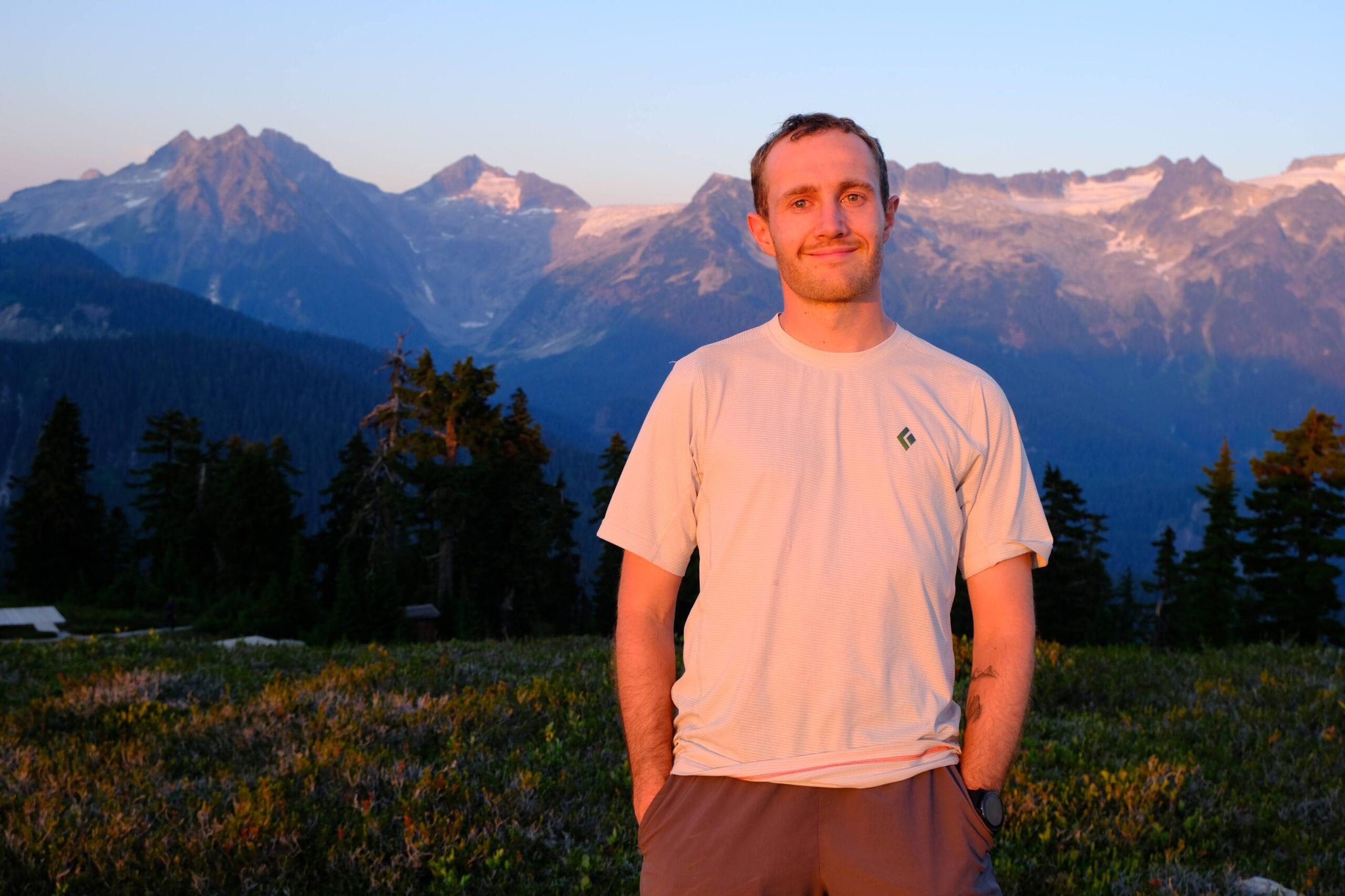 Sunset at Elfin Lakes with a man standing in the alpenglow in a meadow