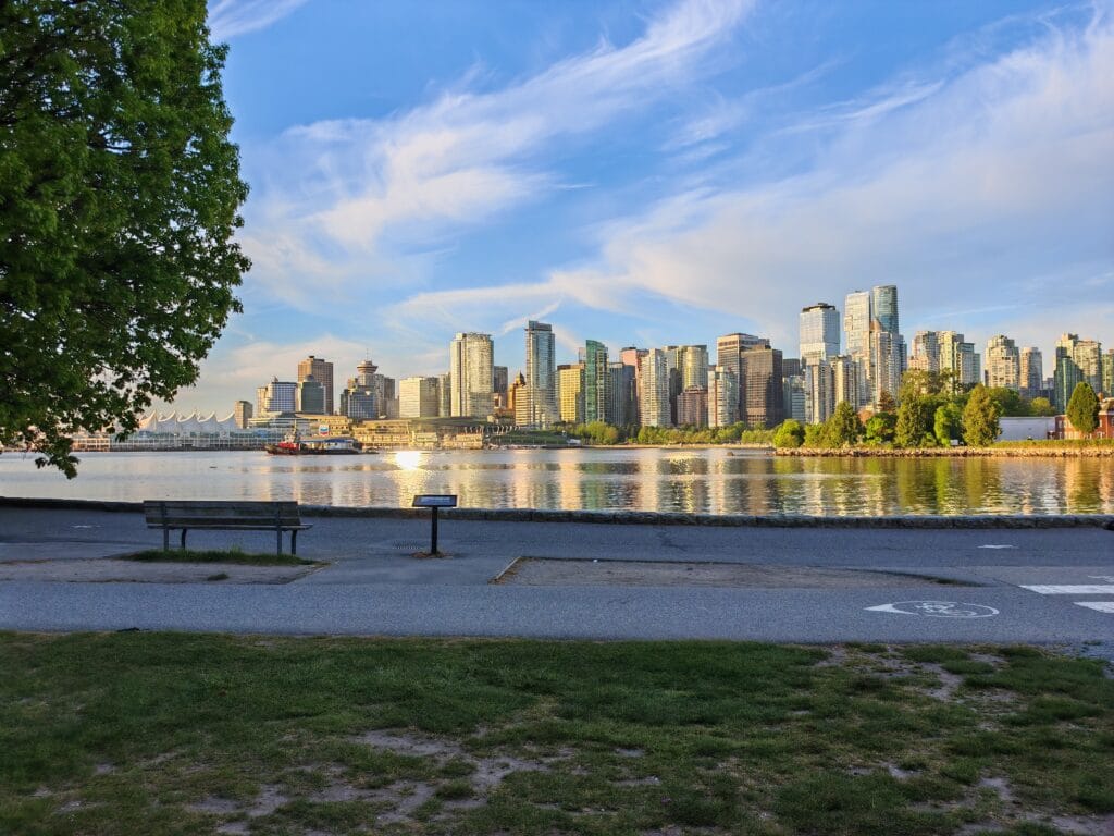 Downtown Vancouver as seen from the seawall in Stanley Park at sunrise with high rise buildings reflecting in the harbour waters