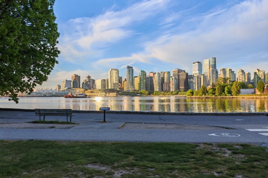 Downtown Vancouver as seen from the seawall in Stanley Park at sunrise with high rise buildings reflecting in the harbour waters, a perk of moving to Canada