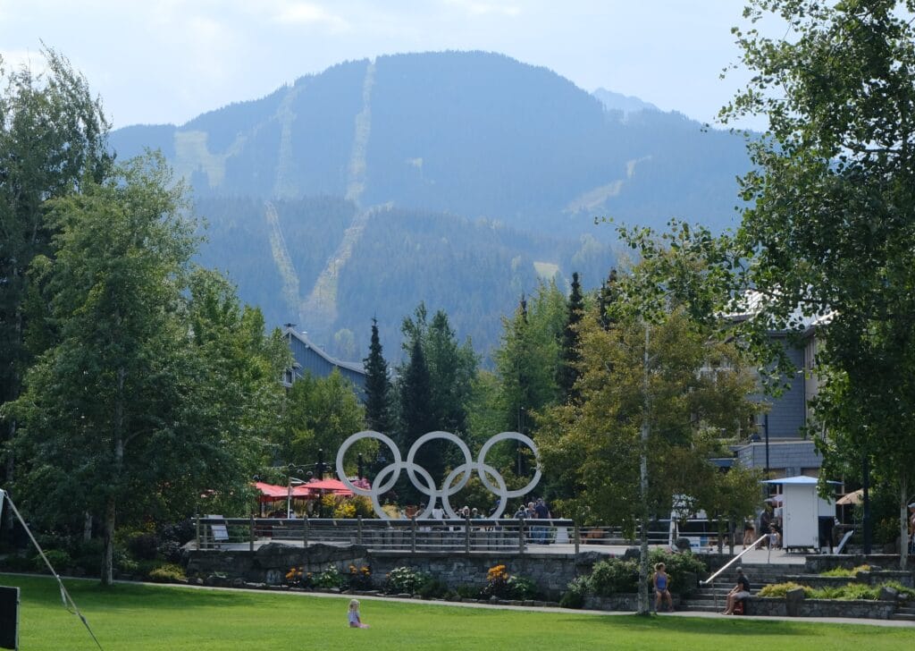 The Olympic Rings in whistler village before the skin slopes and mountains in the background