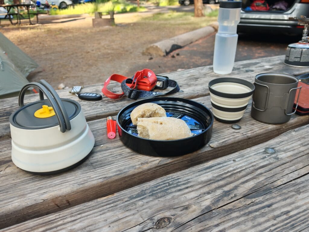 Camp cooking equipment in Yosemite with the sea to summit kettle, mugs and titanium mugs on a wooden bench at camp