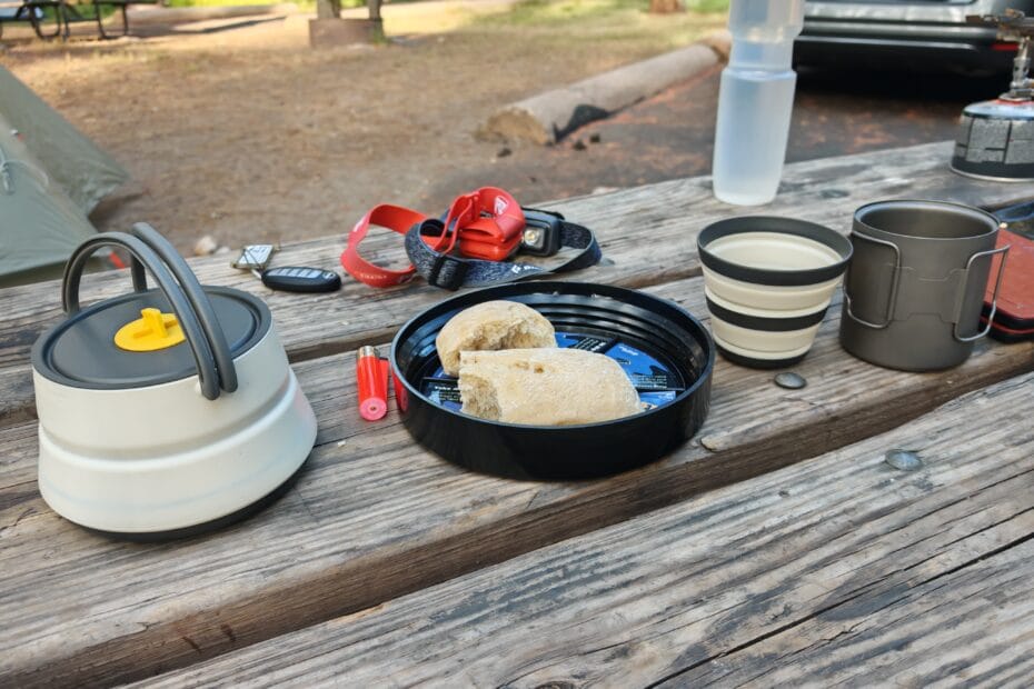 Camp cooking equipment in Yosemite with the sea to summit kettle, mugs and titanium mugs on a wooden bench at camp