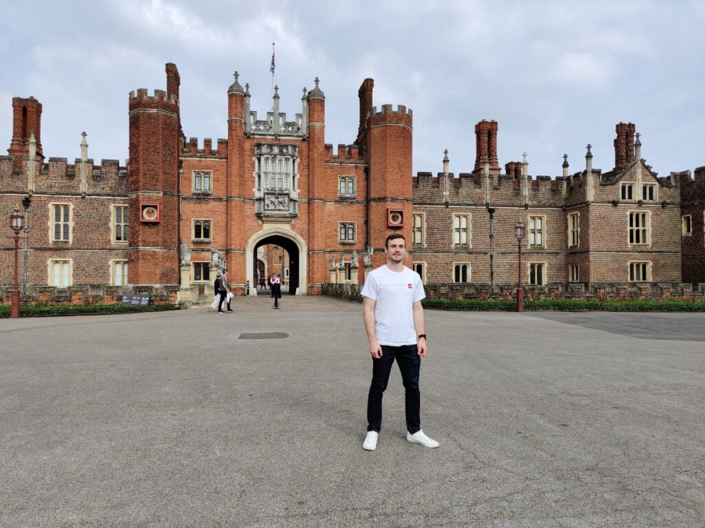 A man standing in front of Hampton Court Palace home to the Tudor King Henry the 8th