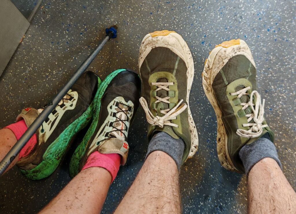 Wet and muddy Norda 002 and Salomon Genesis trail running shoes after a Vancouver trail run with hiking poles