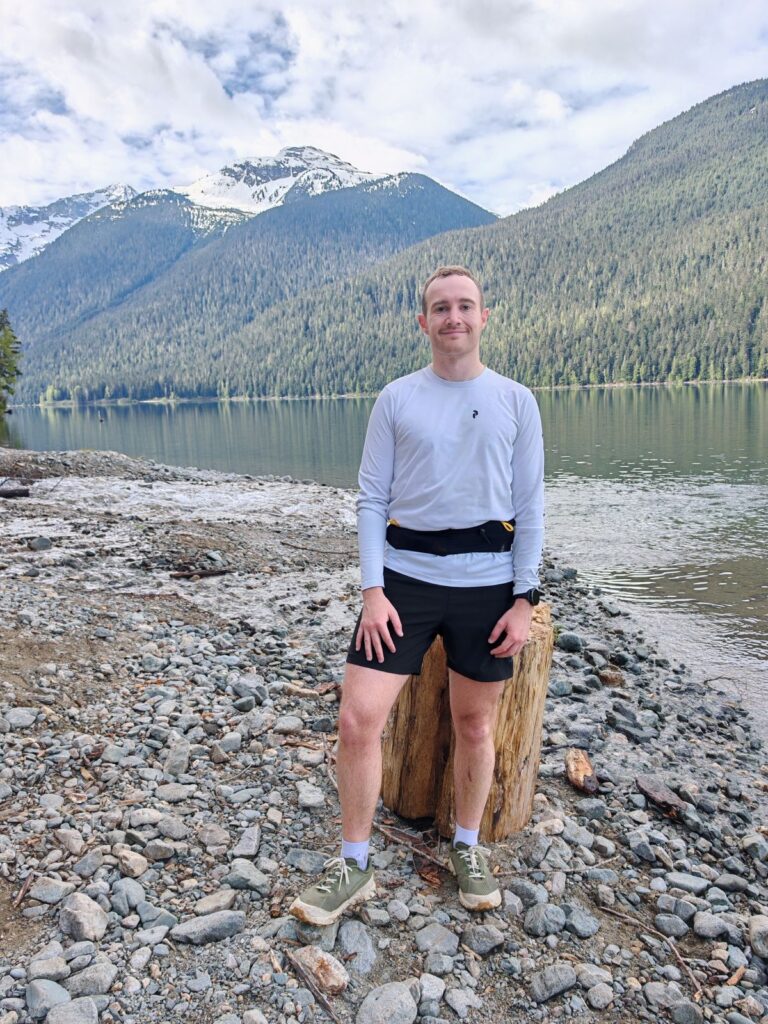 Trail runner wearing the Norda 002 trail runners standing next to a mountain lake at Cheakamus Lake near Whistler, BC