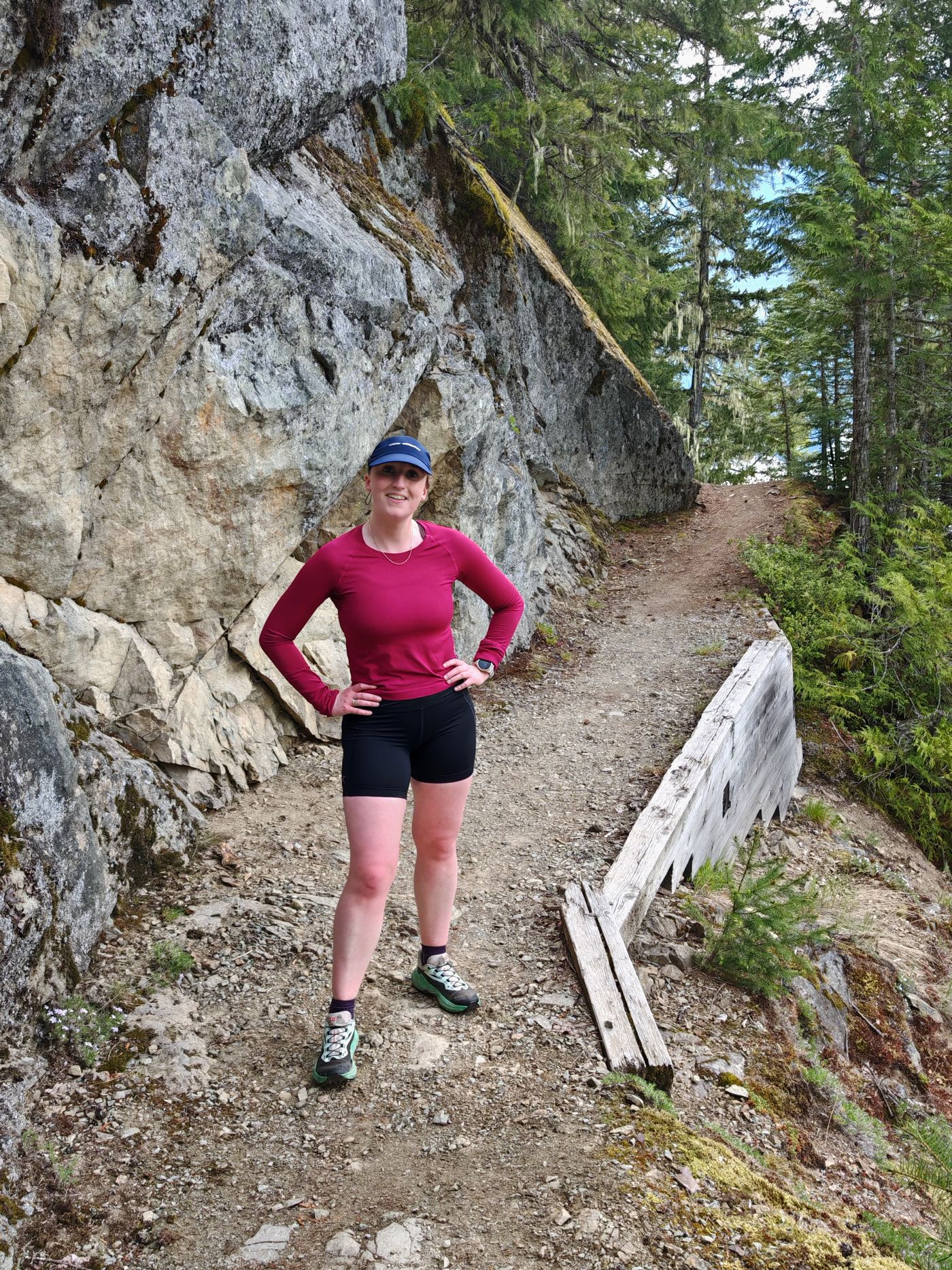 Female runner wearing the Salomon Genesis trail runners on a muddy narrow trail