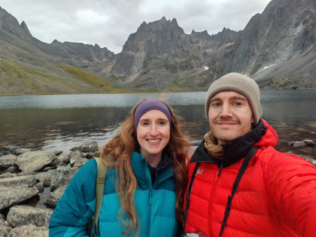 A backpacking couple wearing Arc'teryx Cerium Hoody and Rab Alpine Infinity Down Jacket