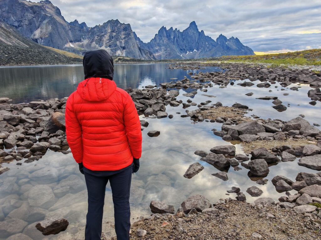 Backpacker in Tombstone Territorial Park wearing the Orange Arc'teryx Cerium Hoody