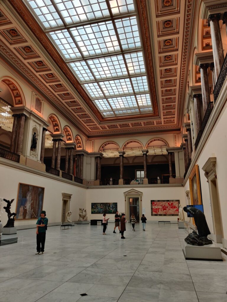 Royal Museums of Fine Arts central hall with statues and vast glass ceiling